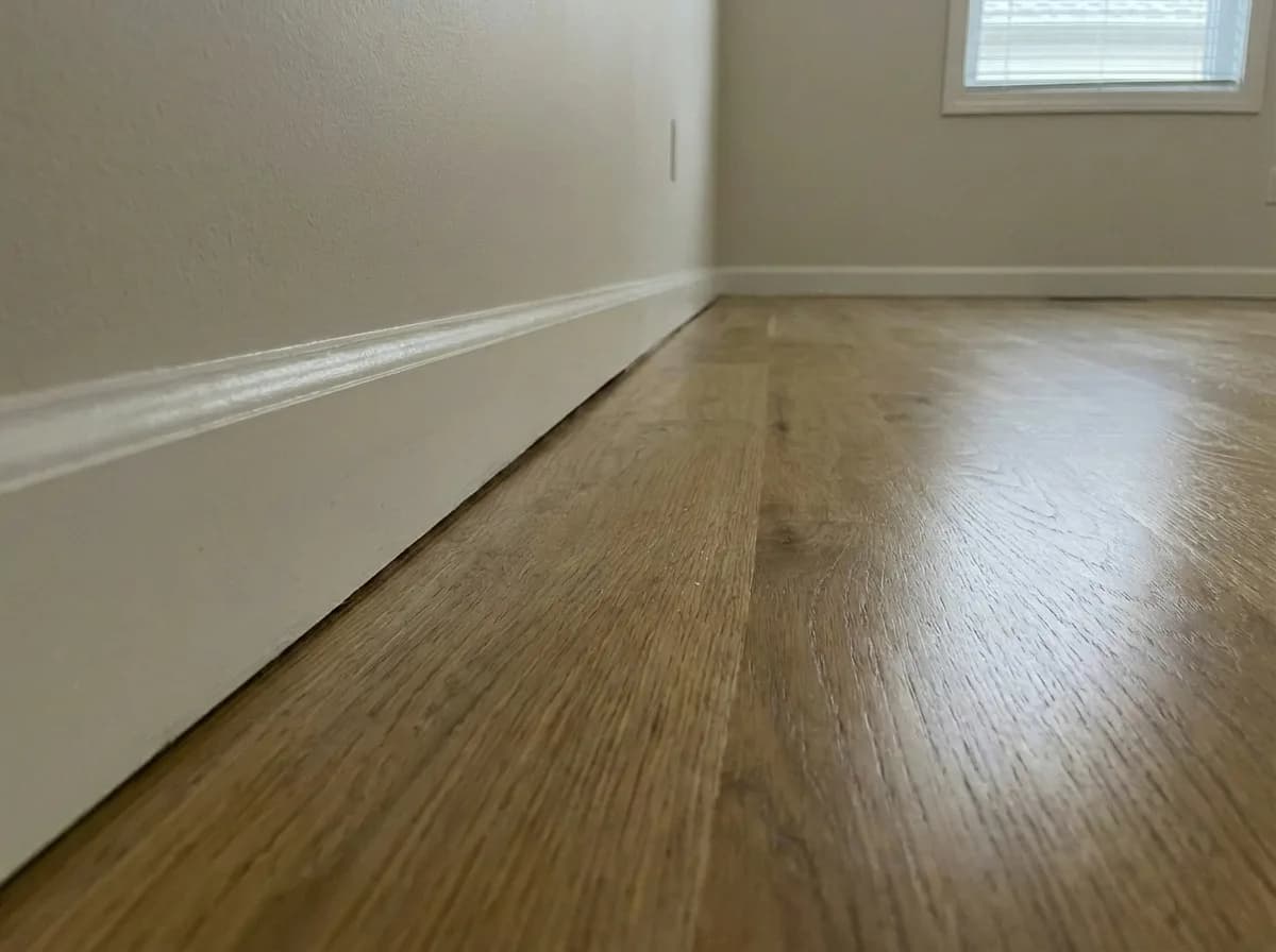 Room with hardwood floors and white baseboards appearing normal and square